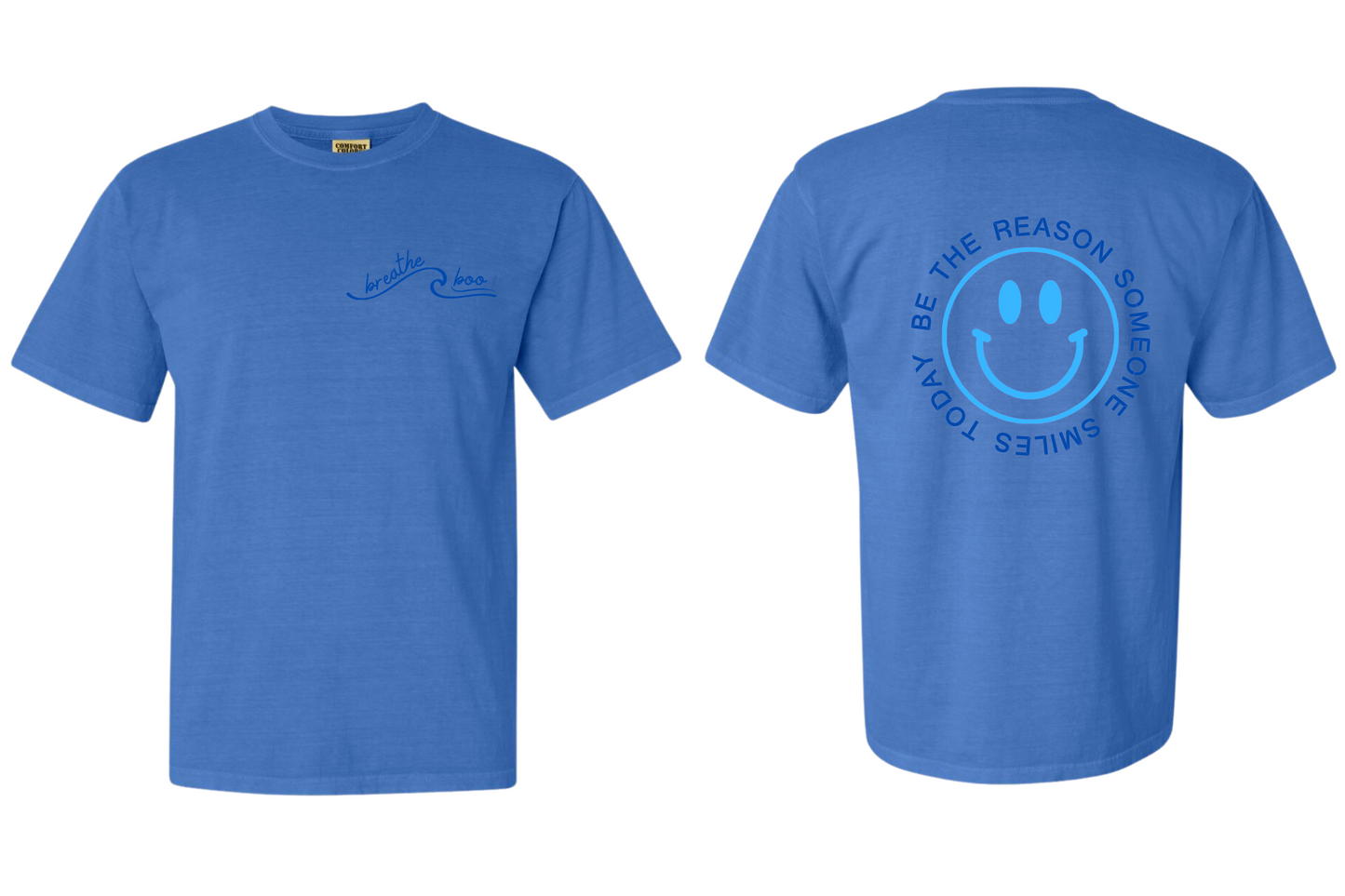 ocean blue short sleeve shirt with "breathe boo" on the left chest area of the shirt and Community Grace on the sleeve in navy blue tones. On the back of the shirt there is a smiley face in a vibrant electric blue color with the words "BE THE REASON SOMEONE SMILES TODAY" around it in capital letters in a navy blue tone