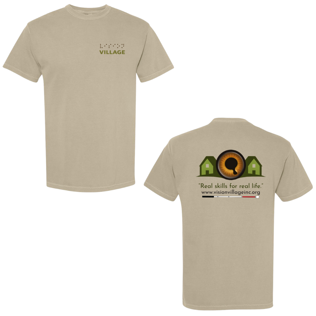 Khaki t-shirt with left chest graphic on the front that has the word vision in braille and the word village in print. The back has the Vision Village logo with the words “real skills for real life” underneath. Below that is the non-profit’s email address, www.visionvillageinc.org, and a graphic of a white cane.