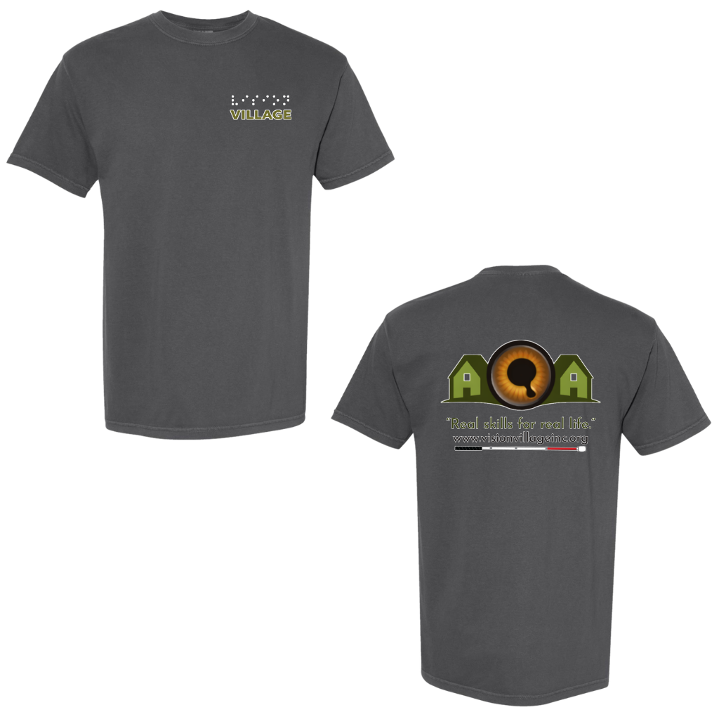 Pepper t-shirt with left chest graphic on the front that has the word vision in braille and the word village in print. The back has the Vision Village logo with the words “real skills for real life” underneath. Below that is the non-profit’s email address, www.visionvillageinc.org, and a graphic of a white cane.