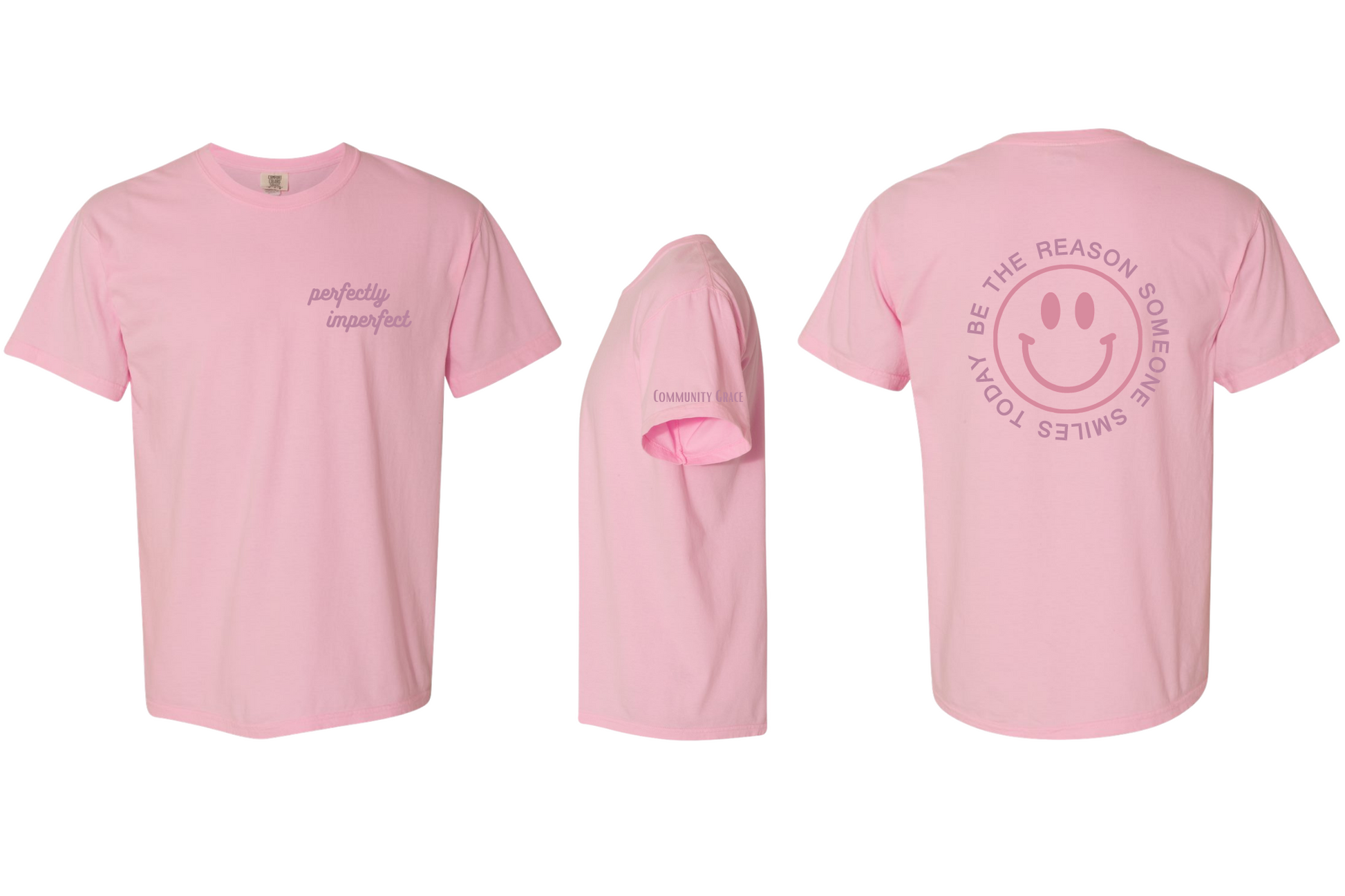 light pink short sleeve shirt with "perfectly imperfect" on the left chest area of the shirt and Community Grace on the sleeve in dark berry tones. On the back of the shirt there is a smiley face in a darker pink color with the words "BE THE REASON SOMEONE SMILES TODAY" around it in capital letters in a darker berry tone.