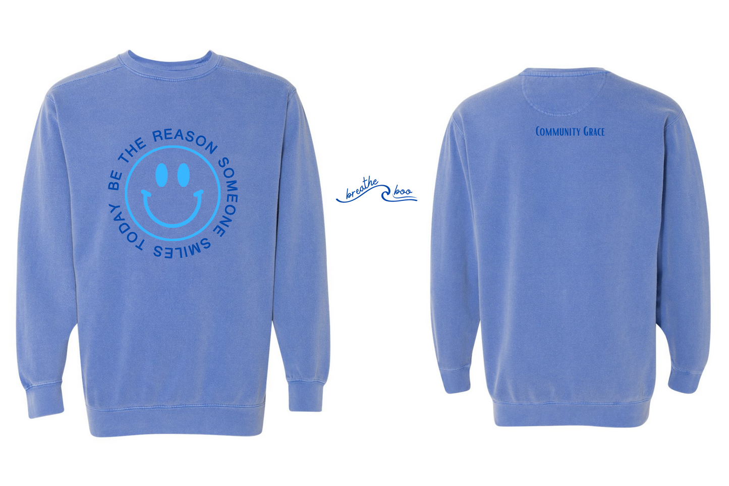 ocean blue crewneck sweatshirt with a smiley face in a vibrant electric blue color with the words "BE THE REASON SOMEONE SMILES TODAY" around it in capital letters in a navy blue tone on the front of the sweatshirt. On the back of the sweatshirt is Community Grace in a navy blue color.  The inner left sleeve of the sweatshirt has the affirmation breathe boo following the shape of a wave